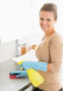 Portrait of smiling housewife cleaning desk in bathroom